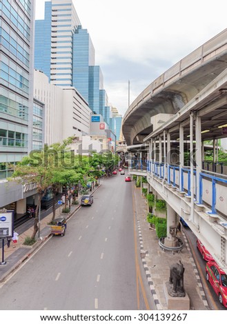 BANGKOK - AUGUST,8 :The flow traffic move on road with pedestrian and sky-train tracks above street when holiday time of middle town. THAILAND AUGUST,8 2015