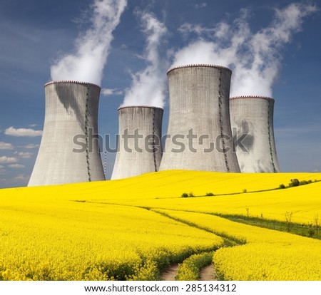 Nuclear power plant Dukovany and golden flowering field of rapeseed with rural road - Czech Republic - two possibility for production of energy