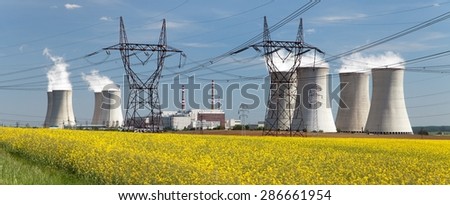 Nuclear power plant Dukovany with golden glowering field of rapeseed - Czech Republic - two possibility for production energy