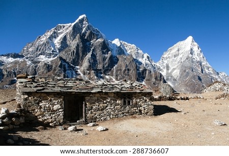Dusa village, typical nepalese stony chalet on the way to Mount Everest base camp, Tabuche peak, mount Cholatse and mount Arakam Tse