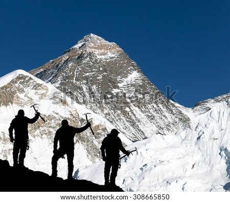 Mount Everest from Kala Patthar from Kala Patthar and silhouette of climbing men with ice axe in hand - trek to everest base camp - Nepal