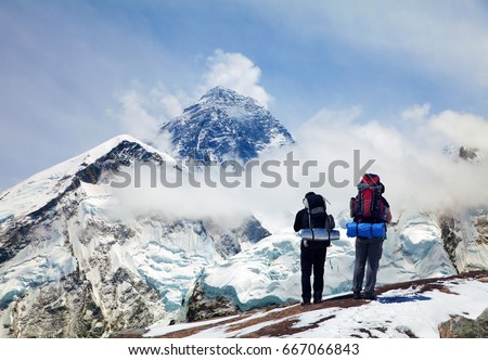 Panoramic view of Mount Everest from Kala Patthar with two tourists on the way to Everest base camp, Sagarmatha national park, Khumbu valley - Nepal