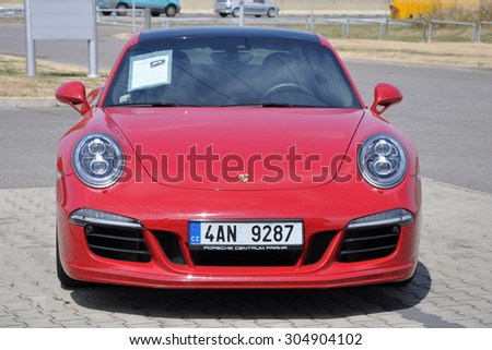 PRAGUE, THE CZECH REPUBLIC, 02.08.2015 - Luxury red Porsche 911 Carrera 4 GTS parking in front of a car store