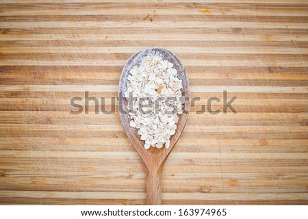 Wooden spoon with cereal product on it on wooden desk background