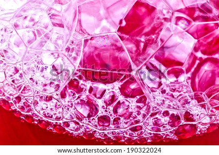 Soap bubbles in red liquid texture.