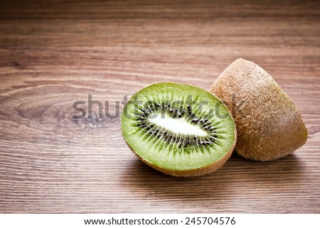 Kiwi fruit cut in studio on wood.