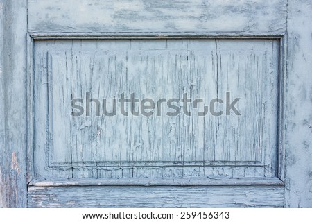 Blue peeling paint on wooden door frame.