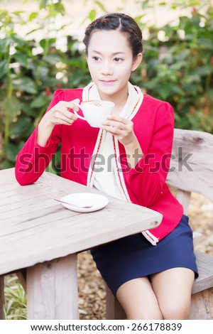 A woman on vacation, I drink coffee. Natural background. Outdoor portrait of cute blonde sitting on terrace and drinking her morning coffee.