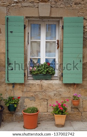 The window with a green shutters, surrounded by flowers. Provence.