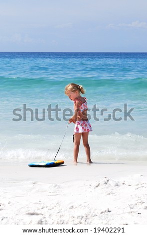 girl on beach in Destin Florida with boogie board