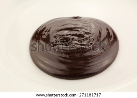 Melted semi-liquid bitter chocolate on a white plate