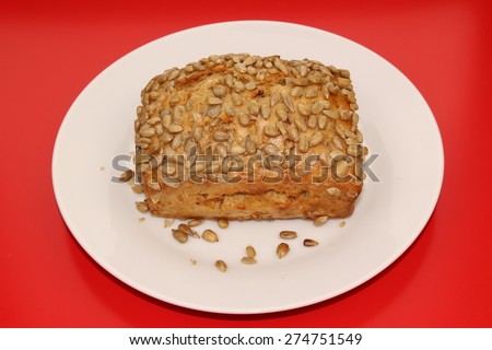 An isolated bread with sunflower seeds on a white plate.  See my other bread images.