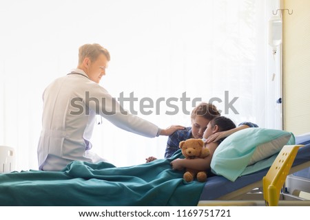 Hand of doctor reassuring Patient family with child patient on hospital bed at the Patient room in hospital / Medical healthcare concept.