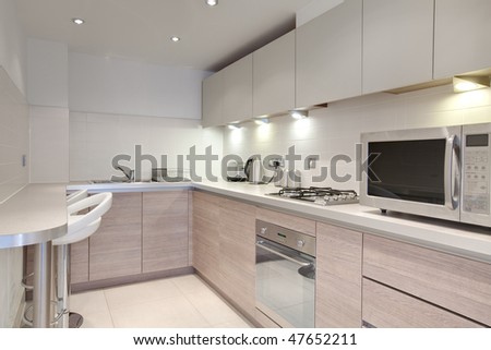 Modern brightly lit kitchen with fitted appliances