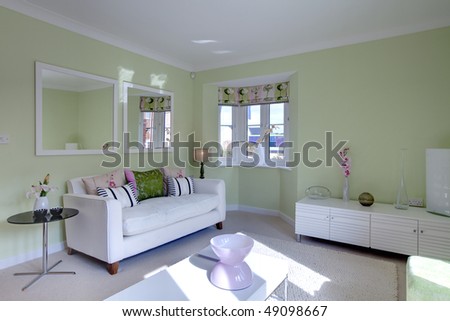 modern contemporary living room with fashionable furniture dresses including sofa dressed with colorful cushions, matching drapes and wall hanging mirrors