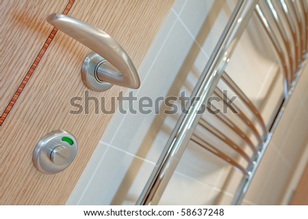 Bathroom door detail with lock in open position and towel rail in the background