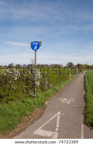 Cycle lane and footpath sign at the beginning of a roadside path in the countryside