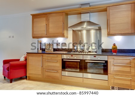 Modern luxury fitted kitchen with built in appliances, hob, stainless steel extractor hood and granite work surfaces
