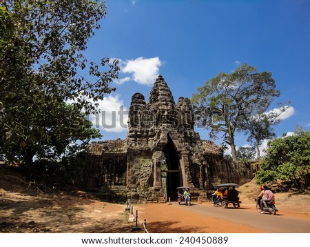 ANGKOR, CAMBODIA - MAY 15, 2013: Unidentified people by Angkor Thom South Gate in Cambodia. Angkor Thom was built in 12th century and was the last and most enduring capital city of the Khmer empire.