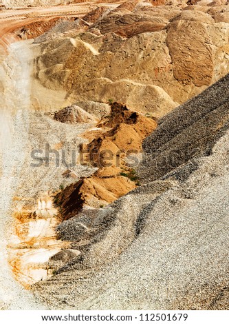 Opencast mine - big heaps of the sand and clay. Gravel and crushed stone for the construction industry in open pit. Sand, gravel and clay in quarries. Industrial landscape with ground texture.