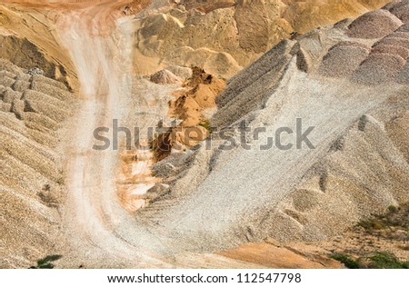 Gravel and crushed stone for the construction in open pit. Open cast mine construction materials - deposits of gravel and sand. Industrial landscape with heaps of the sand, gravel and crushed.
