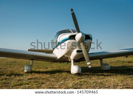 White plane - propeller, wings and fuselage of the aircraft. Retro airplane at the airfield. Aviation transport - travel on sky.