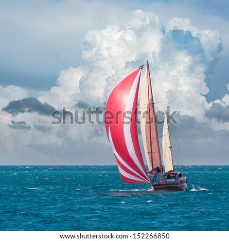 Yacht sailing at waves of the sea. Nautical landscape with sailboat - cruising yacht sailing under full sail taking part in regatta race. Yachting - maritime romantic trip on the yacht with red sails.