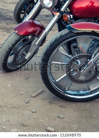 Wheels of motorcycles.  Red motorbike with tire and the wheel closeup on the road.