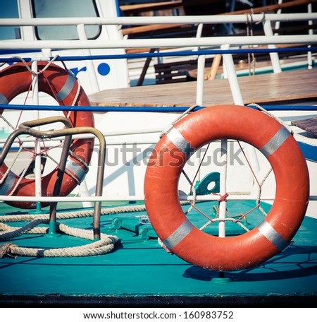 Ship railing and lifebuoy ring. View from the deck of a boat. Sea travel background with lifebuoys.