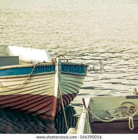 Rowing boats moored at sea port. Fishing boats with reflection on sea surface. Vintage motorboats mooring in harbor.
