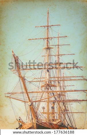 Old Sailing Ship On Paper Texture. Ancient Sailboat On Grunge Background. Exterior Of The Old Tall Ship. Historic Three-Masted Sailing Ship. Vintage Postcards With Sailboat In Retro Style.