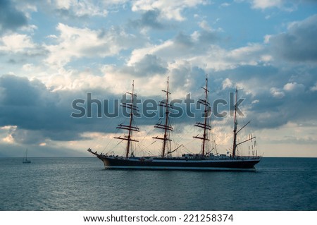 Silhouette of old sailing ship  on sunset. Sea landscape with sailboat of the skyline. Romantic trip on the tall ship during the sea sunset. Historic three-masted sailing ship at cloudy sky.