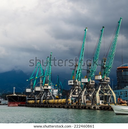 Sea transportation - logistic terminal, freight ship and cranes in the seaport. Industrial sea port with commerce cargo ships.