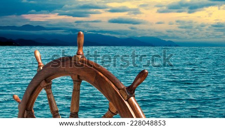 Steering wheel at sea background.  Skipper\'s wheel on an old ship. Sea voyage at the seaside with captains wheel of the old vessel, closeup.