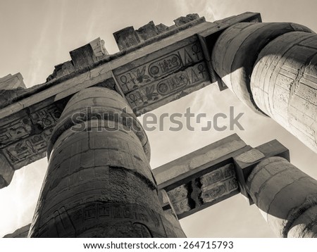 Toned photo of Egypt in retro style, sepia colors. Egyptian columns in Karnak Temple, ancient ruins in Thebes. Travel in Luxor - architecture and landmarks of ancient Egypt.