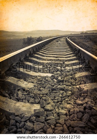 Travel background at old paper texture with empty copy-space for your text. Monochrome railway. Railroad tracks in retro style for travel concept. Old rail road on vintage photo, sepia colors.