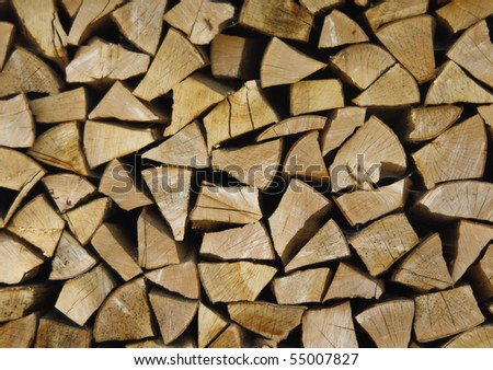 Wood stock background - stacked wood on front-view. Reserve of the pricked firewood for the stove.