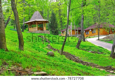 Landscaping design. Dry stream - the way of aqueous flow in the garden among the trees and by arbor is above. Garden stream path with wooden houses flowing through green park landscape.