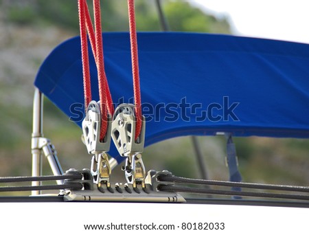 Sailing rigging. Blocks and red cords. Detail of yacht. Ropes of sailboat - tackles on the  rigging yacht. Yachting equipping - pulleys blocks.
