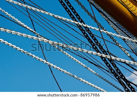 Marine ropes, cables and chains on the sky background. Many chains of the black and white colors.