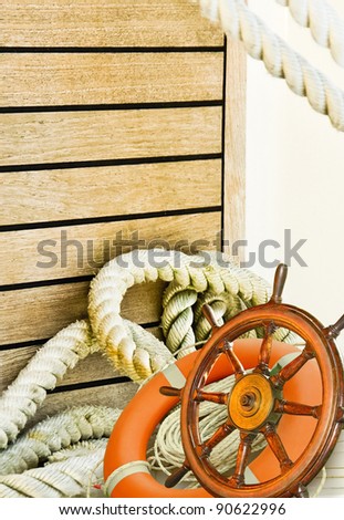 Nautical background, marine travel with adventure collection - sea wheel, ropes, lifebuoy and wooden plank on a white yacht. Ship interior with ropes. Mooring rope turns at the yacht on deck.