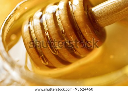 Honey background with wooden dipper.