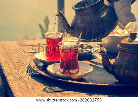 Turkish tea with authentic glass cup and copper tea kettle. Two cups of turkish tea,  toned with vintage instagram filter effect. Istanbul cafe with oriental culture of the street food.