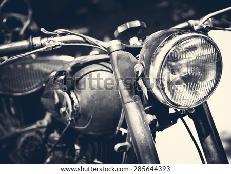 Vintage motorbike, focus on a headlamp. Retro motorcycle with headlight on black and white colors.