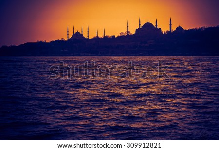 Hagia Sophia and Blue Mosque at sundown. Silhouettes of arabic architecture in sunset -  old mosques in Turkey. Panoramic view of muslim architecture landmarks with minarets in old Istanbul.