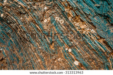 Iron ore texture closeup - natural minerals in the mine. Stone texture of open pit. Extraction of minerals for heavy industry - the texture of the rock containing iron ore and copper.