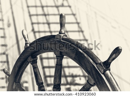 Ancient ship with captain wheel in retro style. Steering wheel on the old sailboat. Sea voyage on the sailing vessel. Travel on the wooden tall ship, skipper steering wheel in front view.