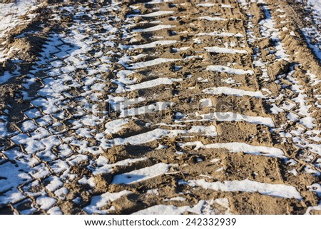 Texture, background is. Tread truck on a dirt road with frozen snow.