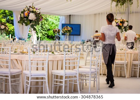 Flowers. Banquet hall in white, working waiters. Wedding.