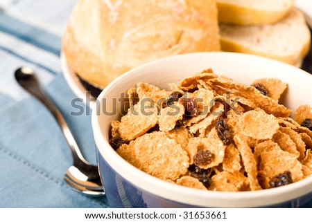Raisin bran cereal accompanied by bread and butter